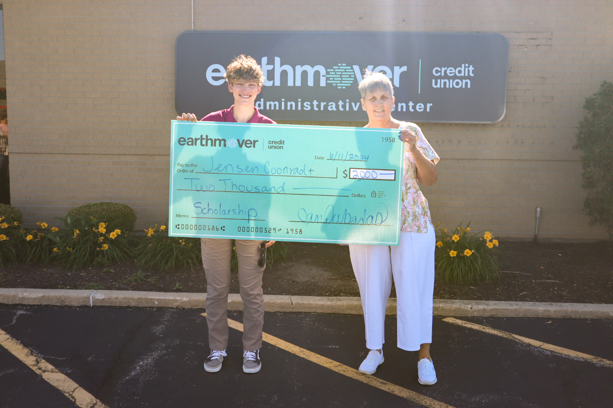 Student and woman holding large check