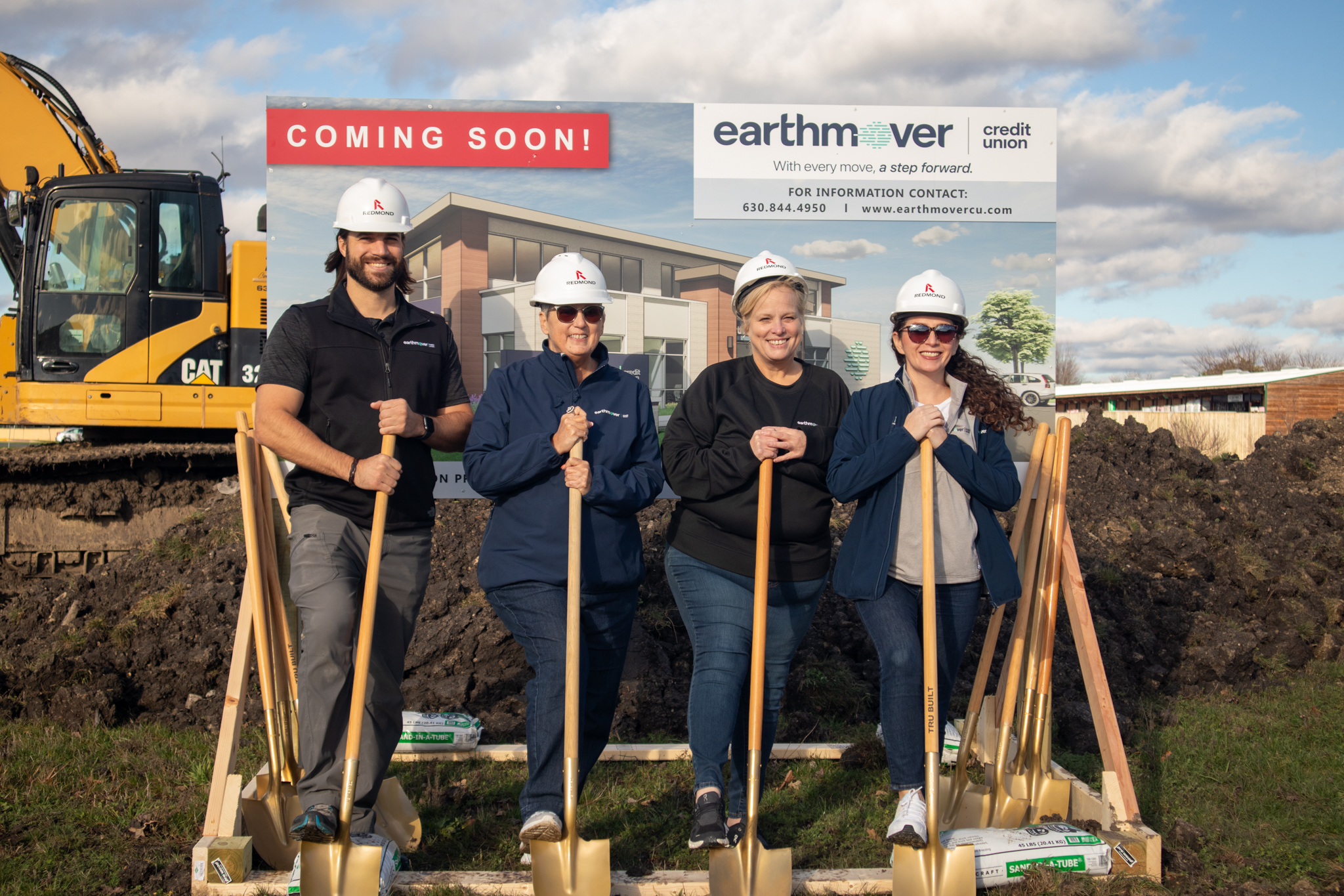 Four individuals posing with shovels 