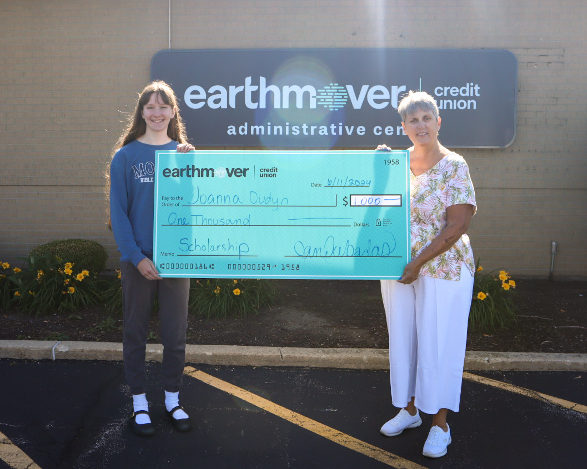 Student and woman holding giant check